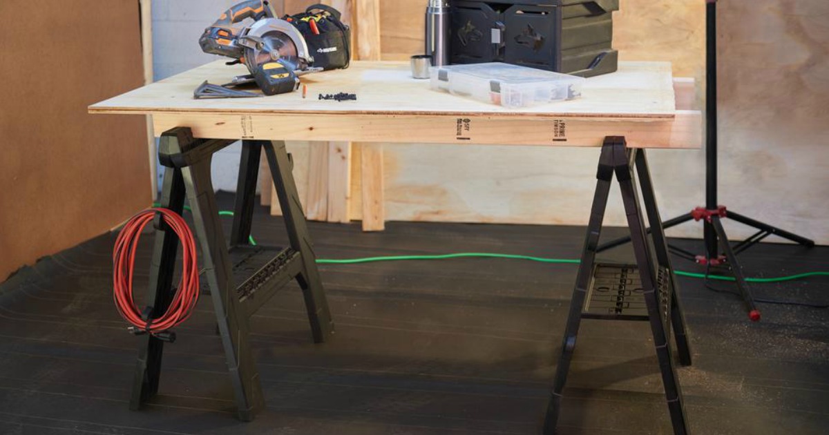 folding sawhorses set up with wood as a table, plus tools