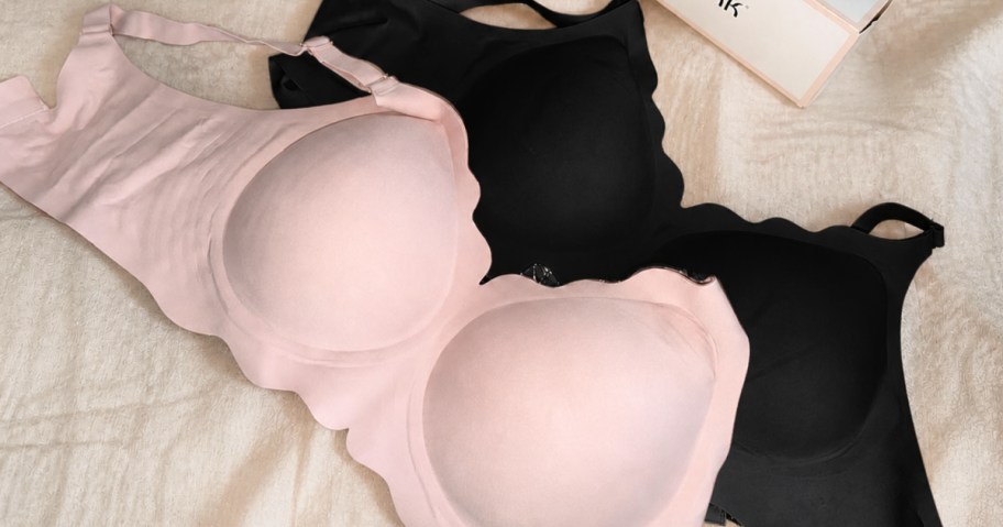 Pink and black jelly bras on white bedding