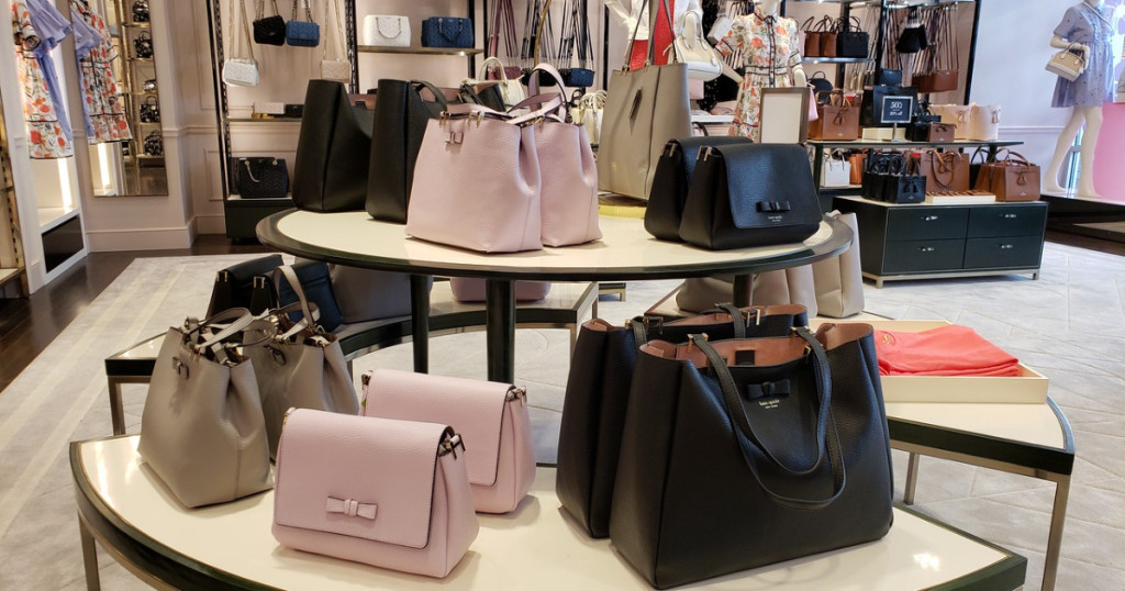 Kate Spade handbags displayed on table at department store 