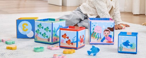 toddler playing with Ms. Rachel blocks on the floor