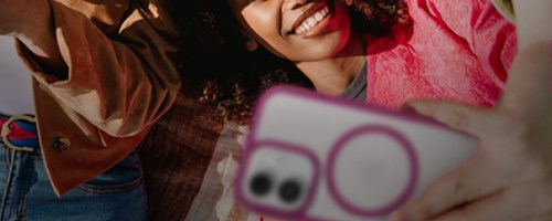 Hand holding pink and white OtterBox phone case while women look at screen
