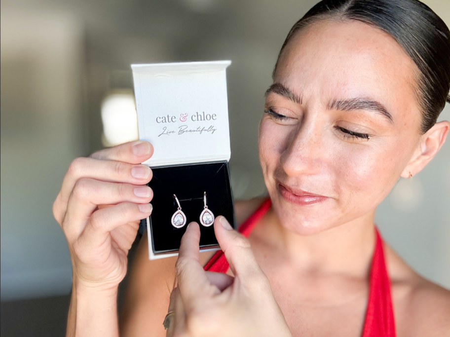 woman holding earrings in box