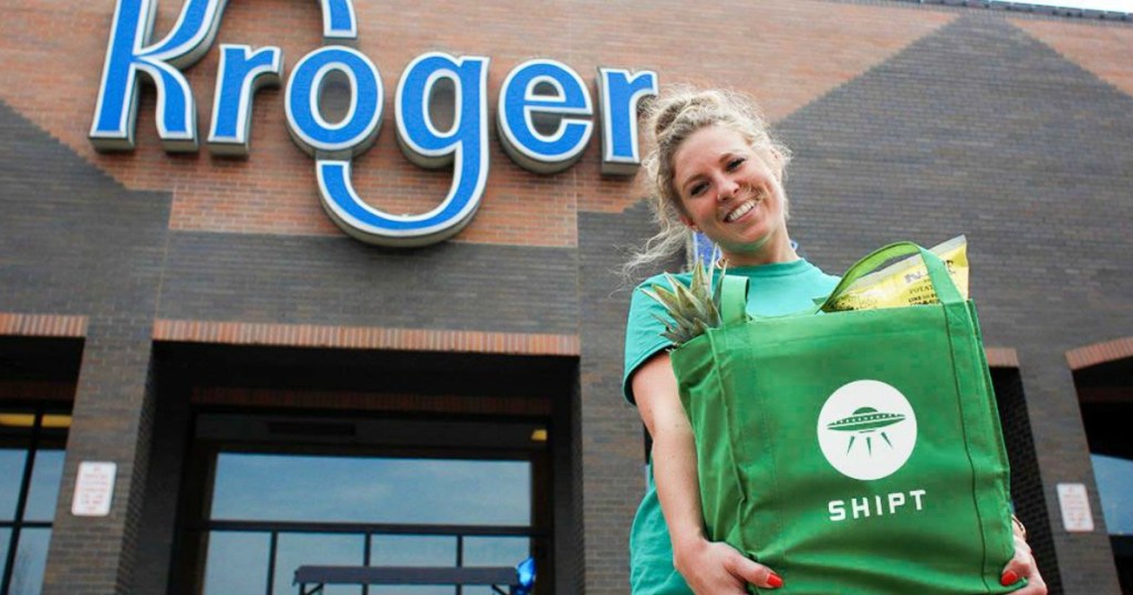 Shipt Shopper holding green reeusable bag outside of Kroger
