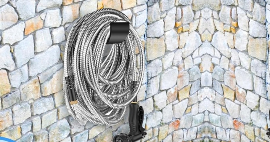 Stainless steel hose hanging on stone wall