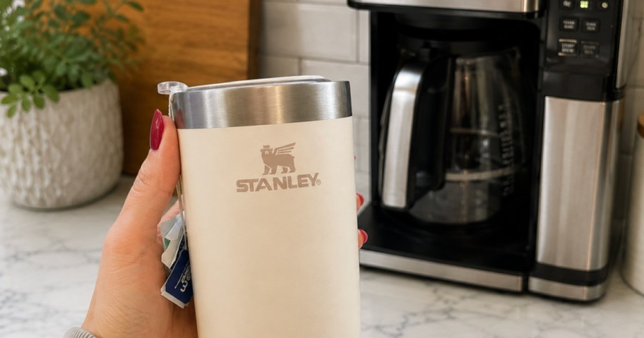 And holding cream colors, Stanley cup in front of coffee maker