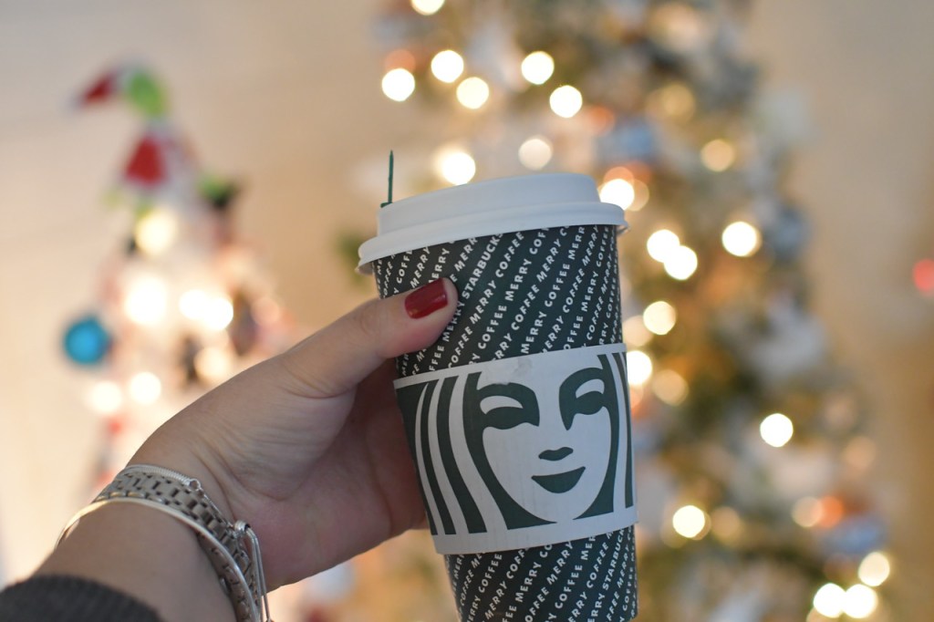Starbucks coffee cup being held by a womans hand