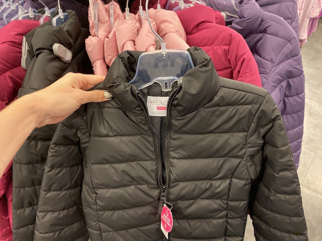 Woman holding gray colored The Children's Place Puffer Jacket