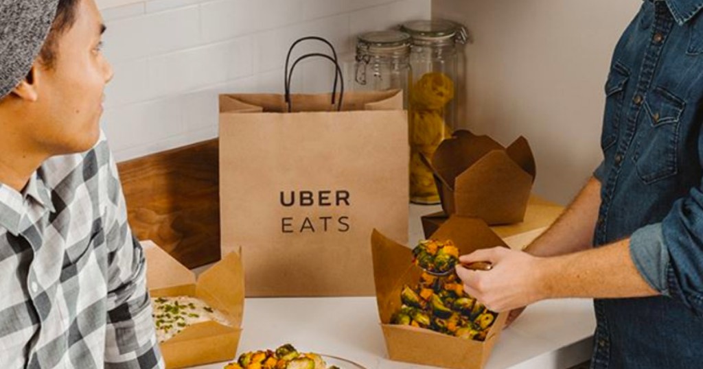People eating takeout from Uber Eats on counter with bag