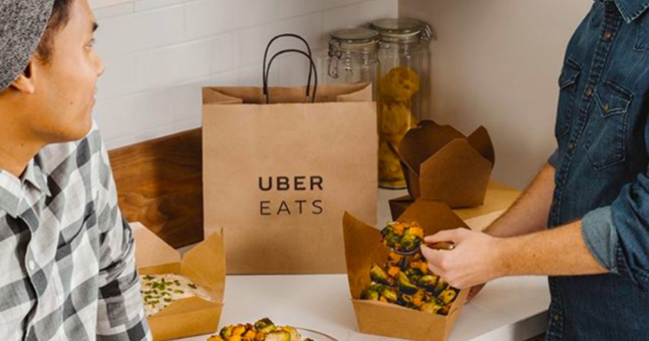 People eating takeout from Uber Eats on counter with bag