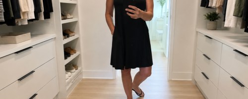 Woman wearing black time and tru dress and standing inside closet