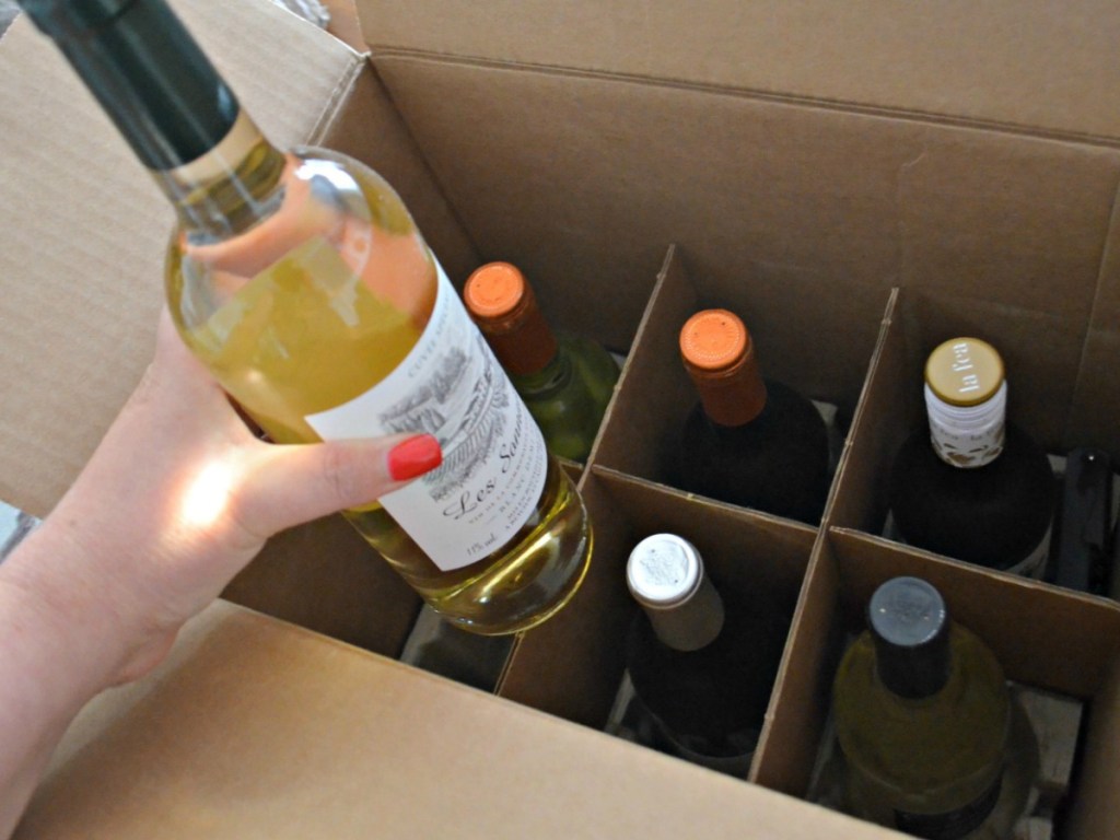 Woman pulling out wine from box