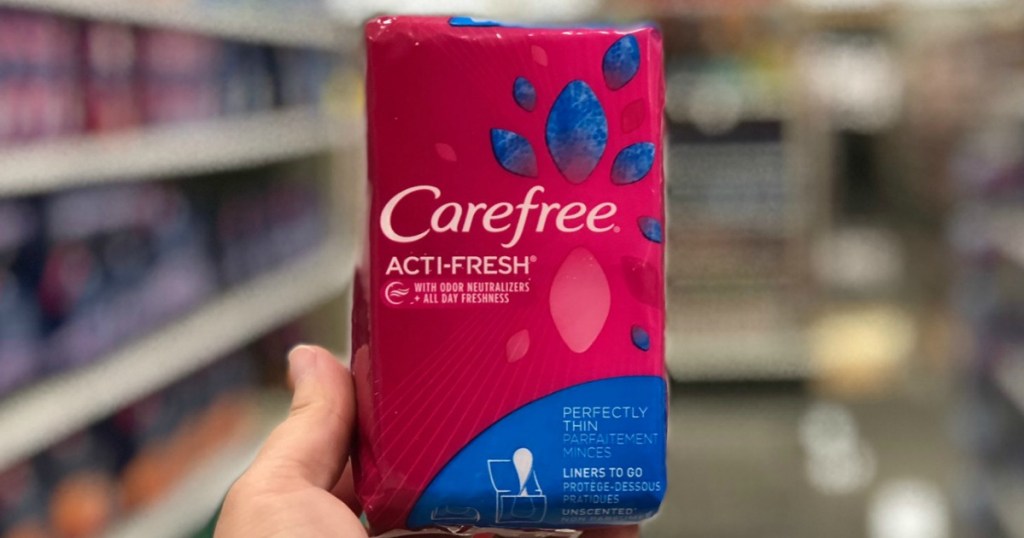 hand holding pink pack of feminine care products