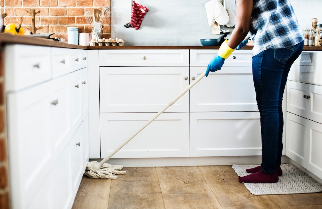 woman mopping floor and doing chores higher babysitting rates