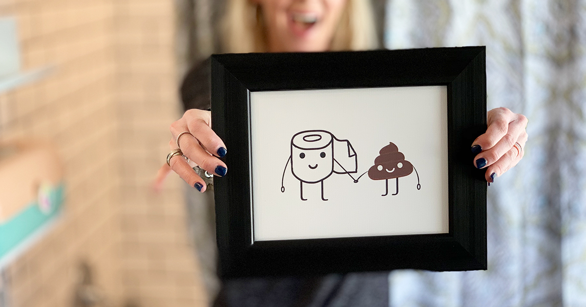 collin holding up framed poop artwork
