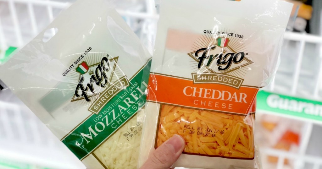 hand holding bags of shredded cheese