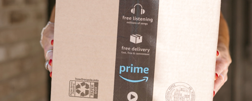 person holding an Amazon shipping box
