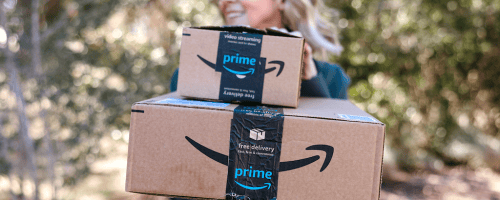 woman posing behind stacked amazon boxes