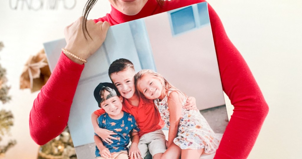 woman holding canvas of three kids