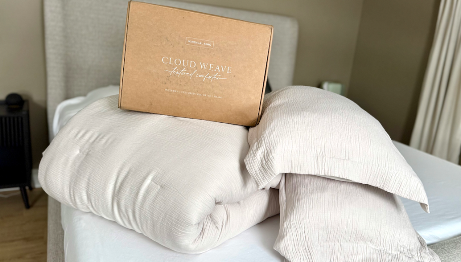 beige comforter and pillows on bed with box 