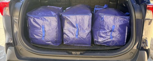 blue moving bags in the back of an SUV