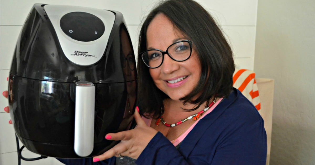 woman smiling holding air fryer