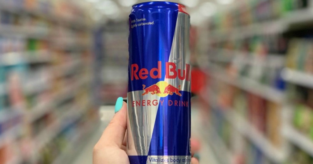 Large can of Red Bull Energy Drink in hand in-store 