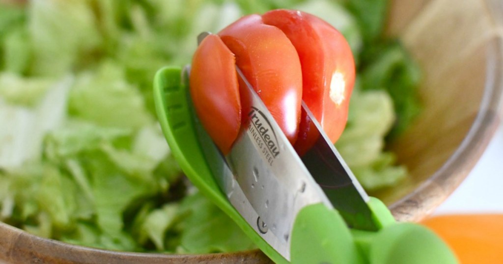 cutting through tomatoes with salad tongs 