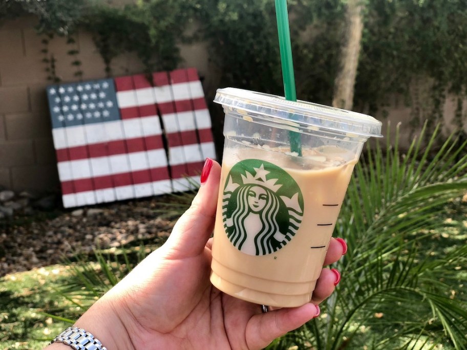 hand holding up a starbucks drink