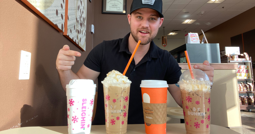 man with 4 Dunkin beverages