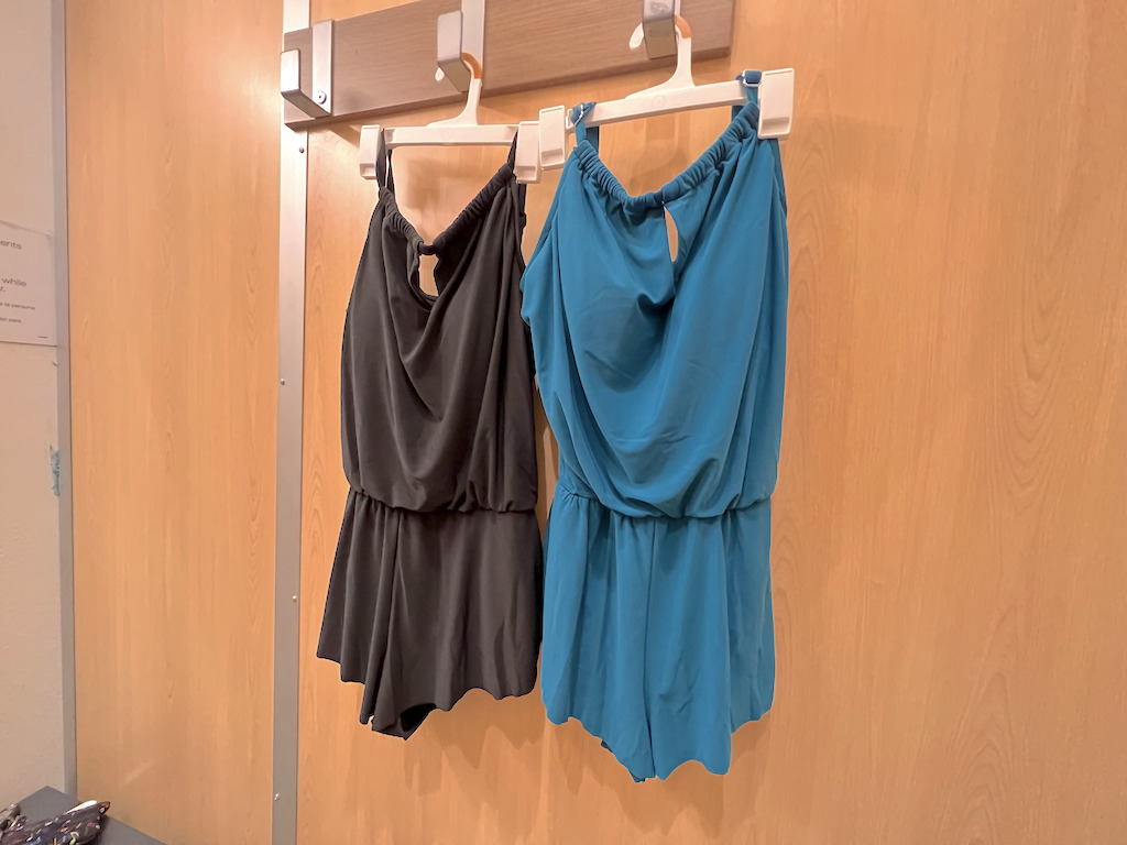 Two swim rompers on hangers at a store