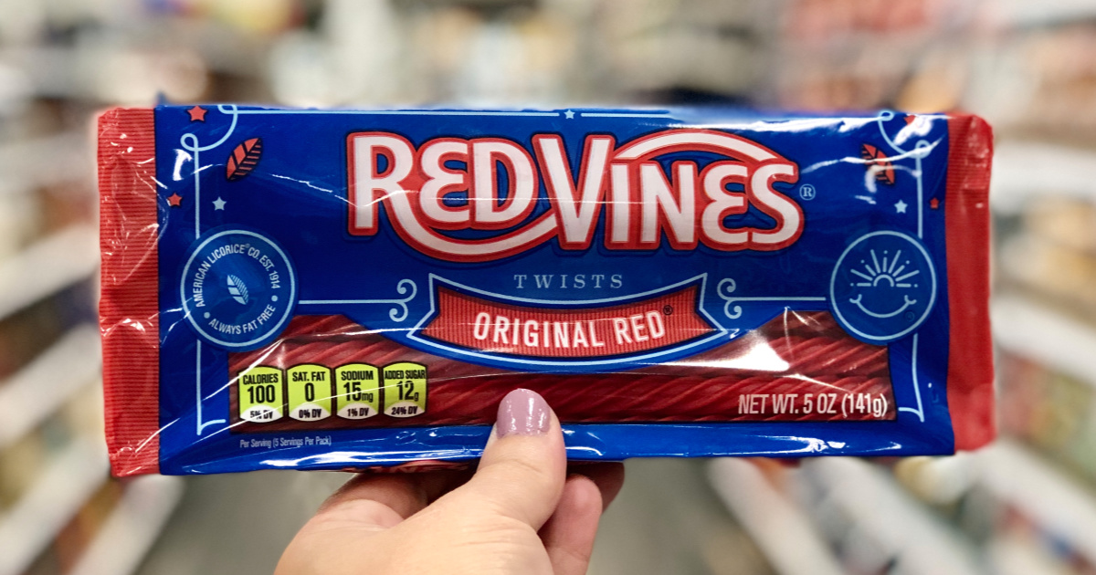 hand holding up a pack of red vines candy in a store aisle