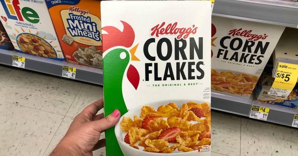 Box of Kellogg's Corn Flakes in hand in-store