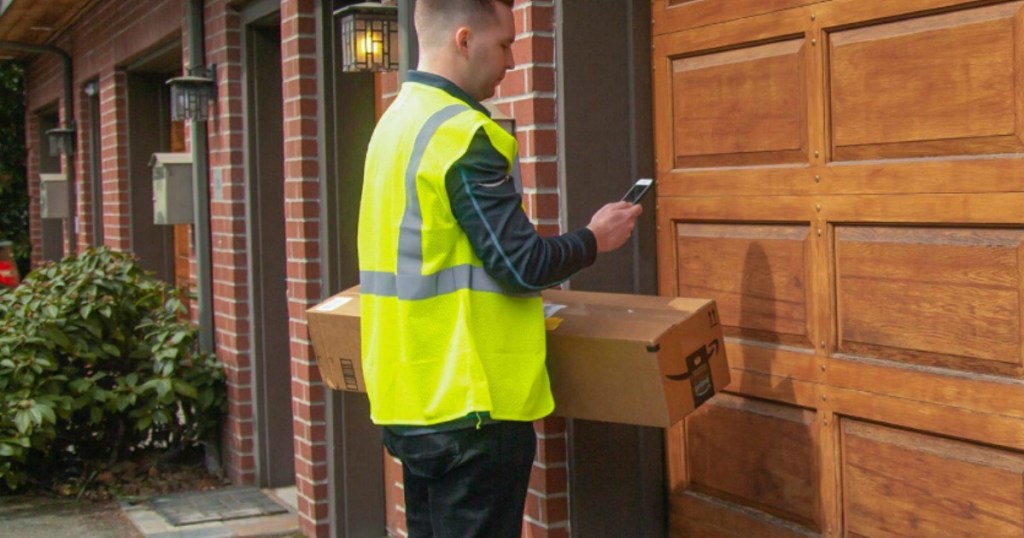 amazon delivery person standing in front of a garage door