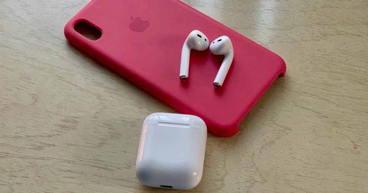 apple air pods with charging case laying on phone