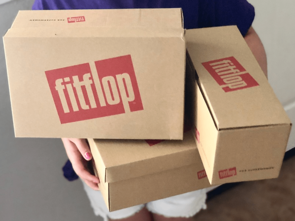 Three FitFlop boxes stacked and being held by a girl
