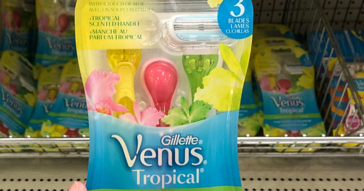 Gillette Venus Tropical Razors being held up in front of a bin of disposable razors