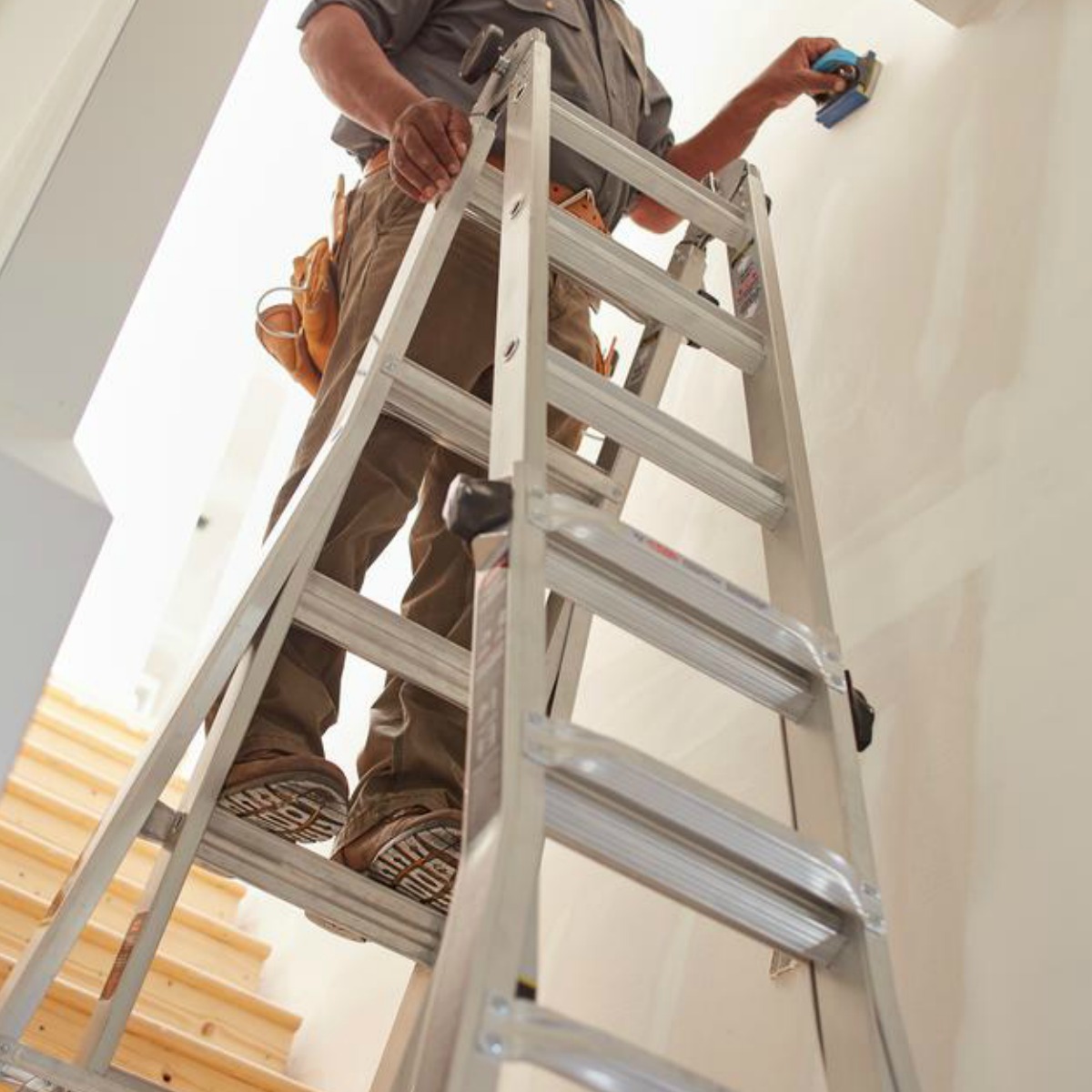 man standing on a ladder in a hallway 