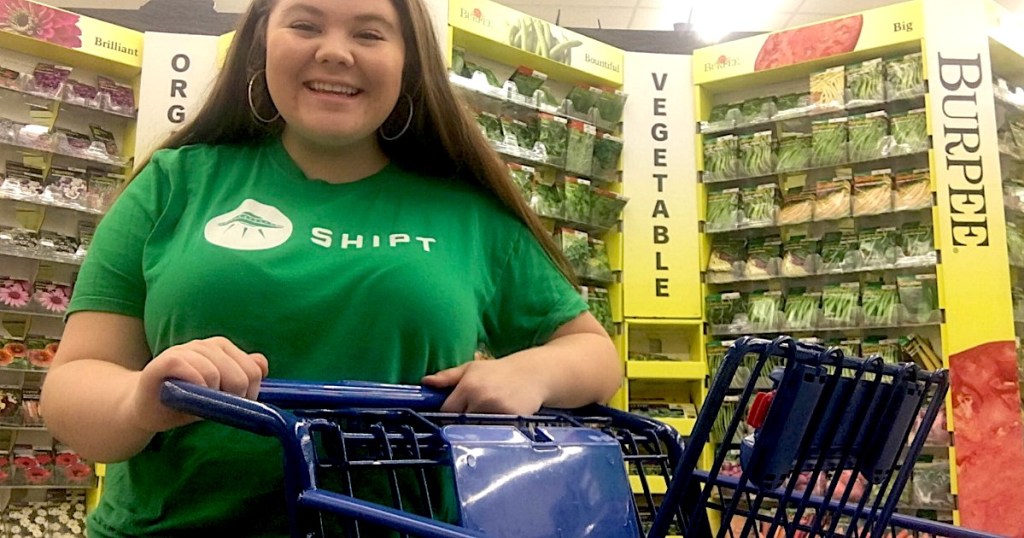 woman wearing green Shipt shirt inside store with cart