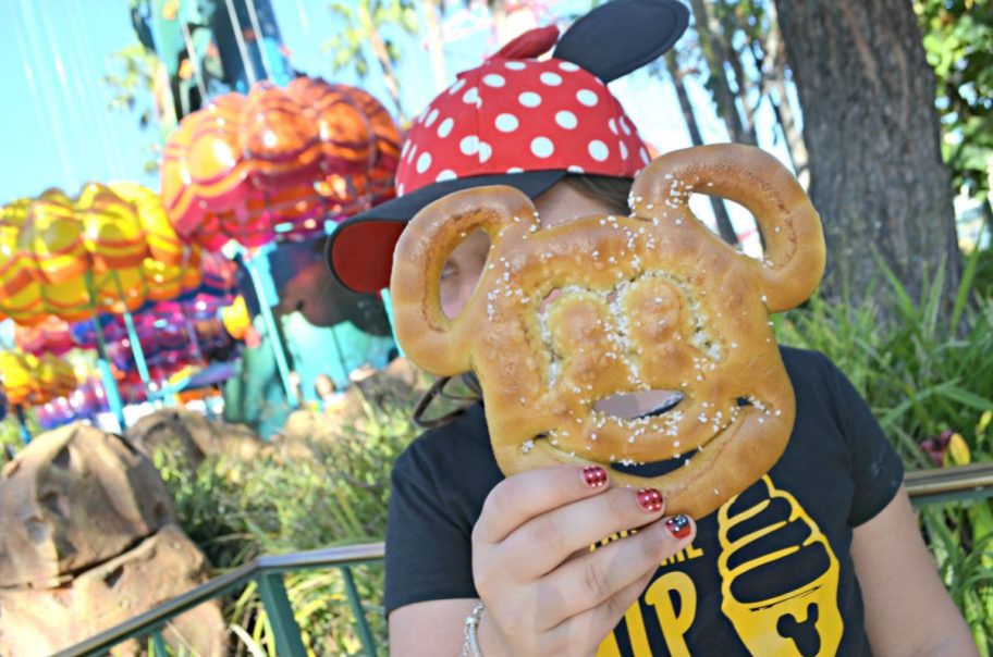 kid holding a Mickey shaped pretzel