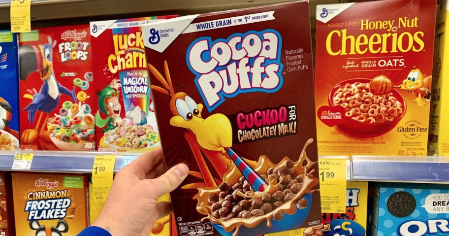 hand holdign box of cocoa puffs cereal 