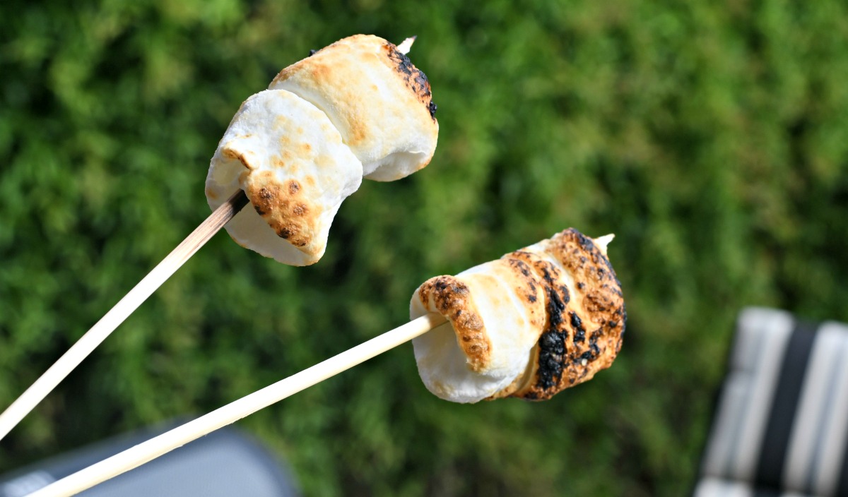 roasting marshmallows to make campfire smores in a bag as a cookout or camping dessert idea