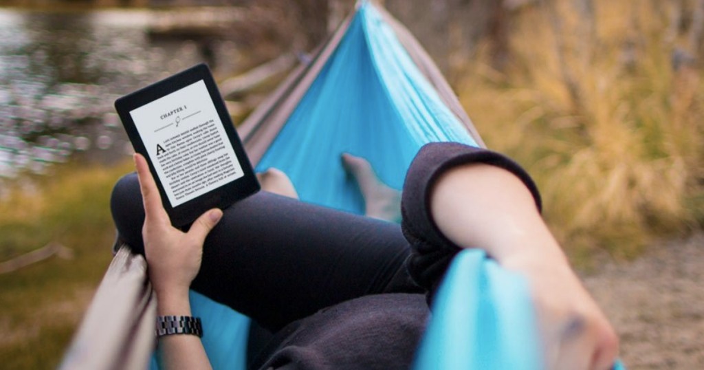 person reading kindle paperwhite in hammock outside