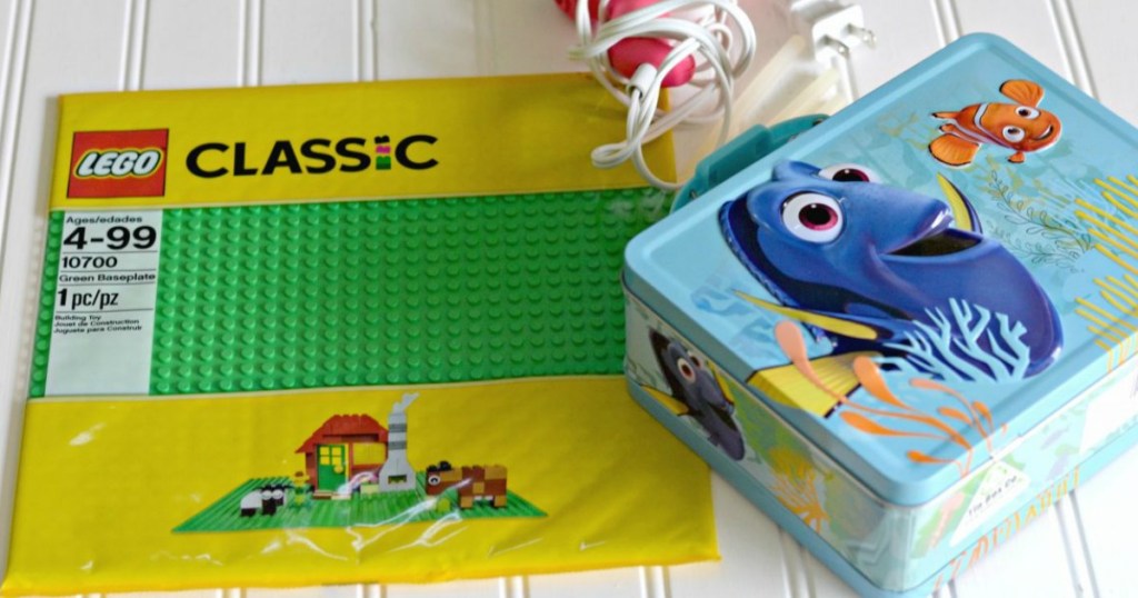 lego classic green baseplate next to finding dory lunch box