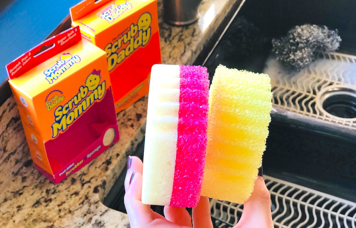 hand holding a yellow and bright pink sponge 