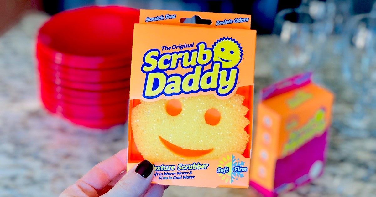 hand holding a scrub daddy sponge in box 