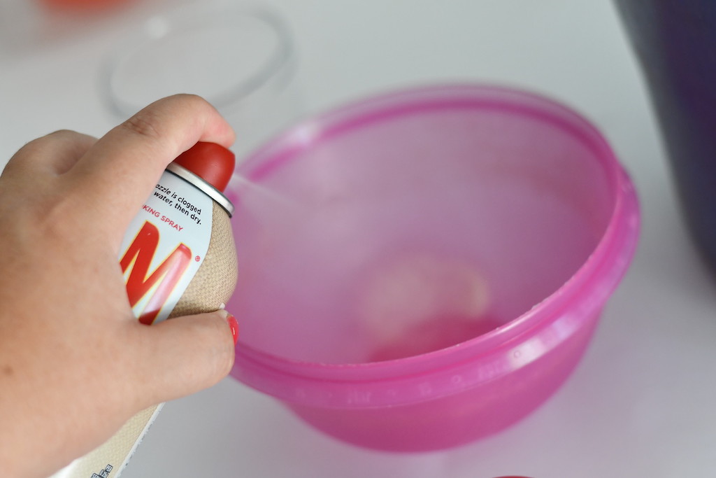 spraying cooking pam spray in plastic container