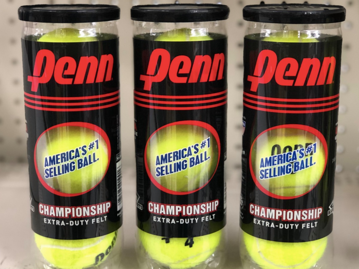 three containers of tennis balls on shelf