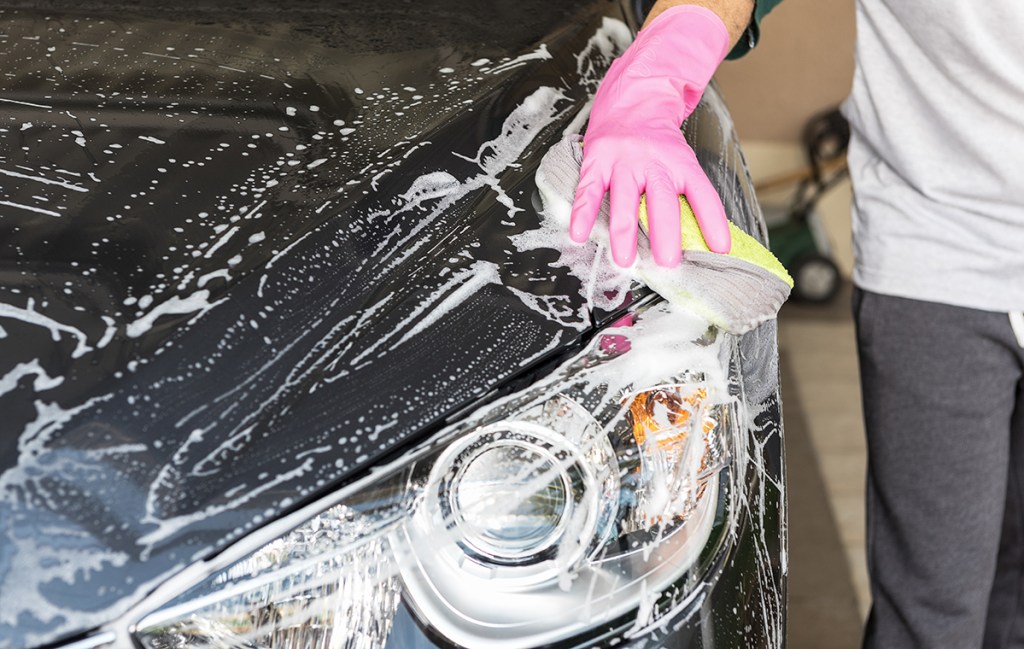 black car being washed with soap and sponge