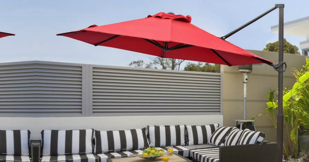 Red Abba Patio offset 11 foot outdoor umbrella on patio with stripe outdoor couch
