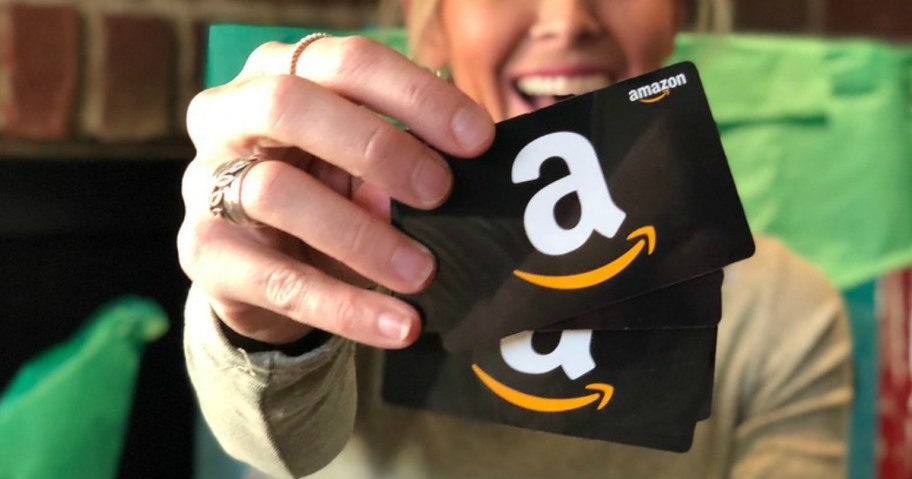 woman holding up amazon gift cards